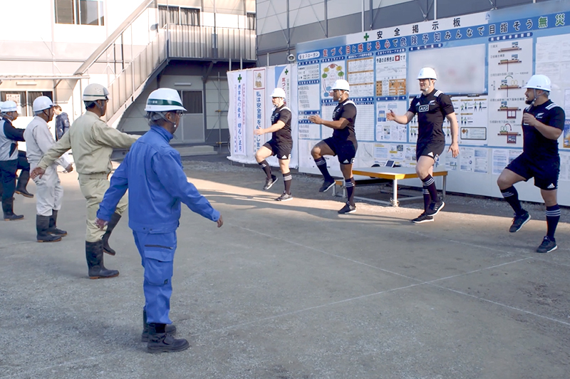 奥村組の建設現場で「けんせつ体幹体操」に挑戦するオールブラックス