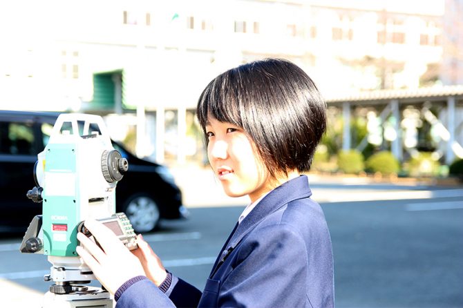 トータルステーションを前にする中本璃音さん。将来は土木技術職を目指している