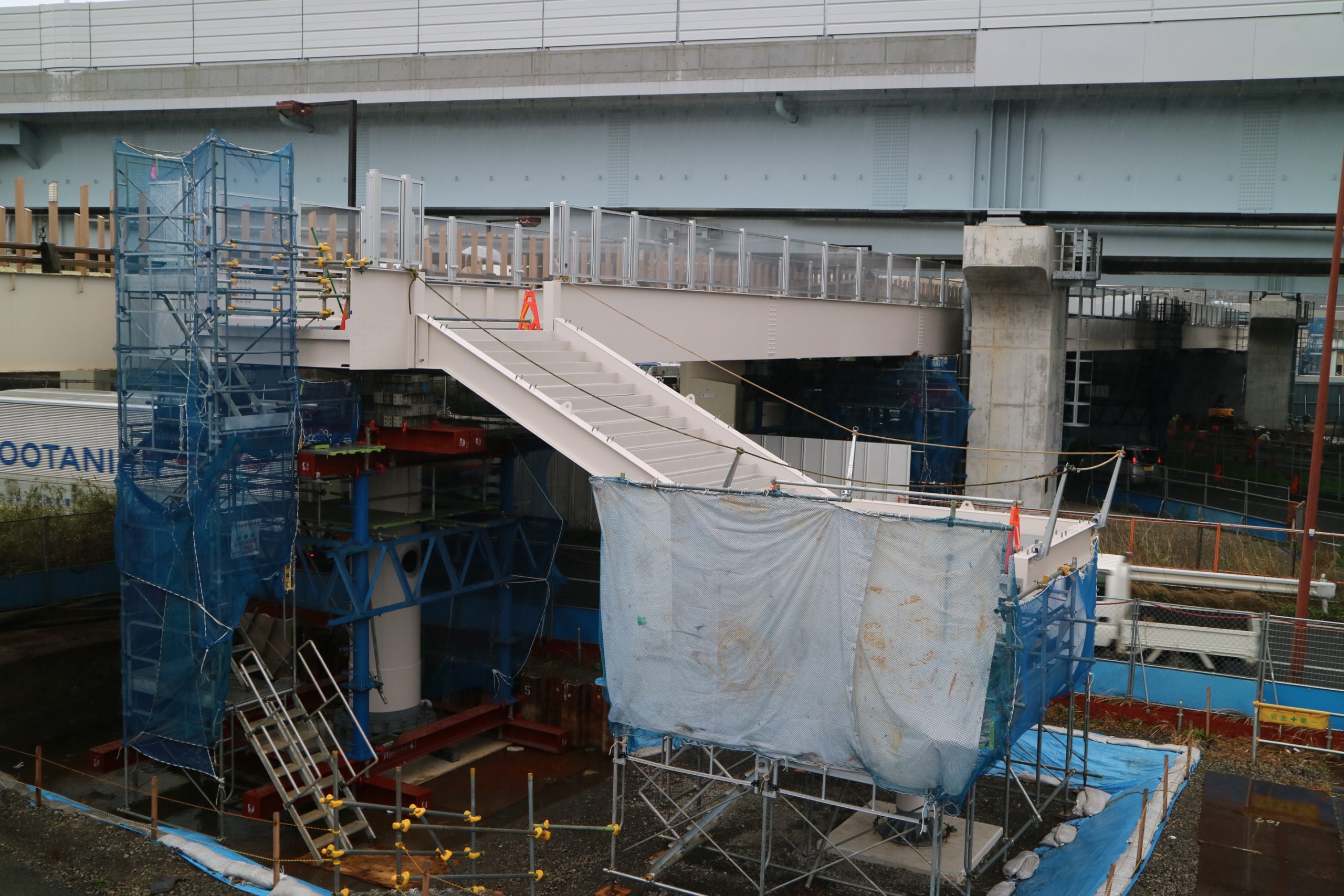 架設中の歩道橋。既設歩道橋と並行する。その直上を走るのは首都高速湾岸線(今年3月上旬時点)。