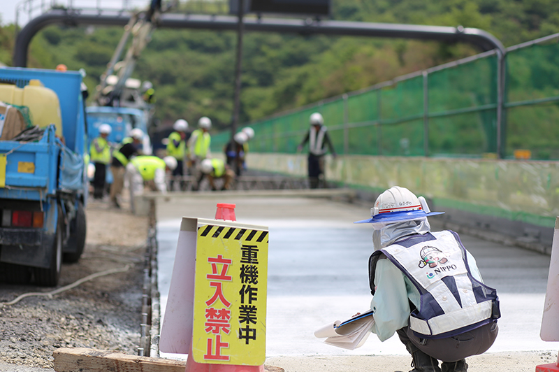 コンクリート舗装の平坦性などの仕上がりを確認する中川さん