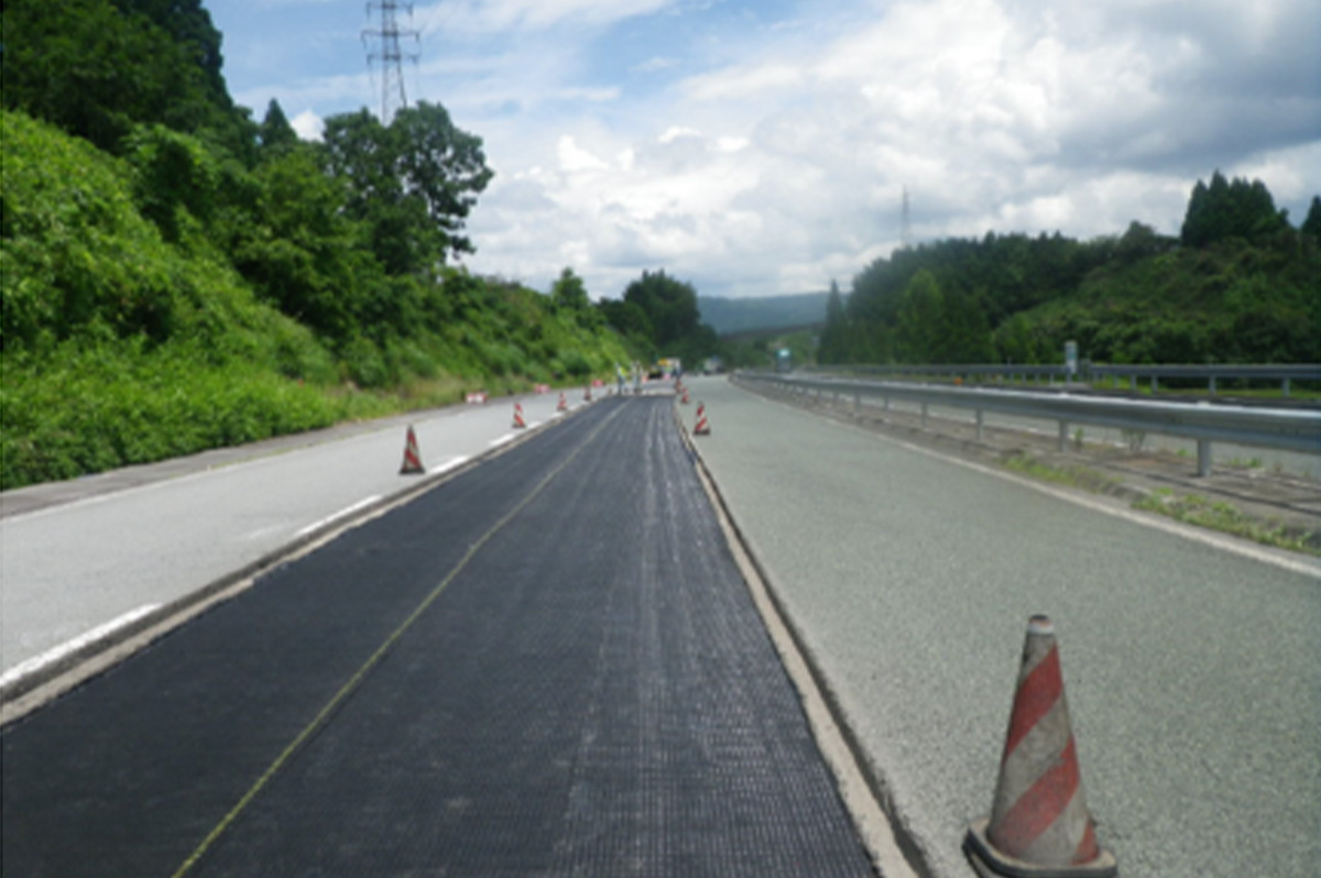 NETIS登録製品であり、道路のひび割れの発生を抑制するシート状の素材「グラスグリッド」を敷設した状態