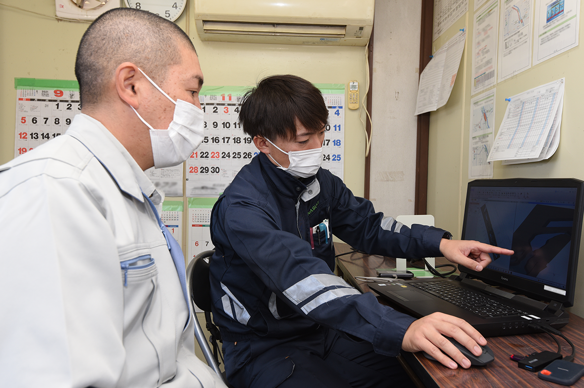後輩にレクチャーする稲川さん(金杉建設提供)