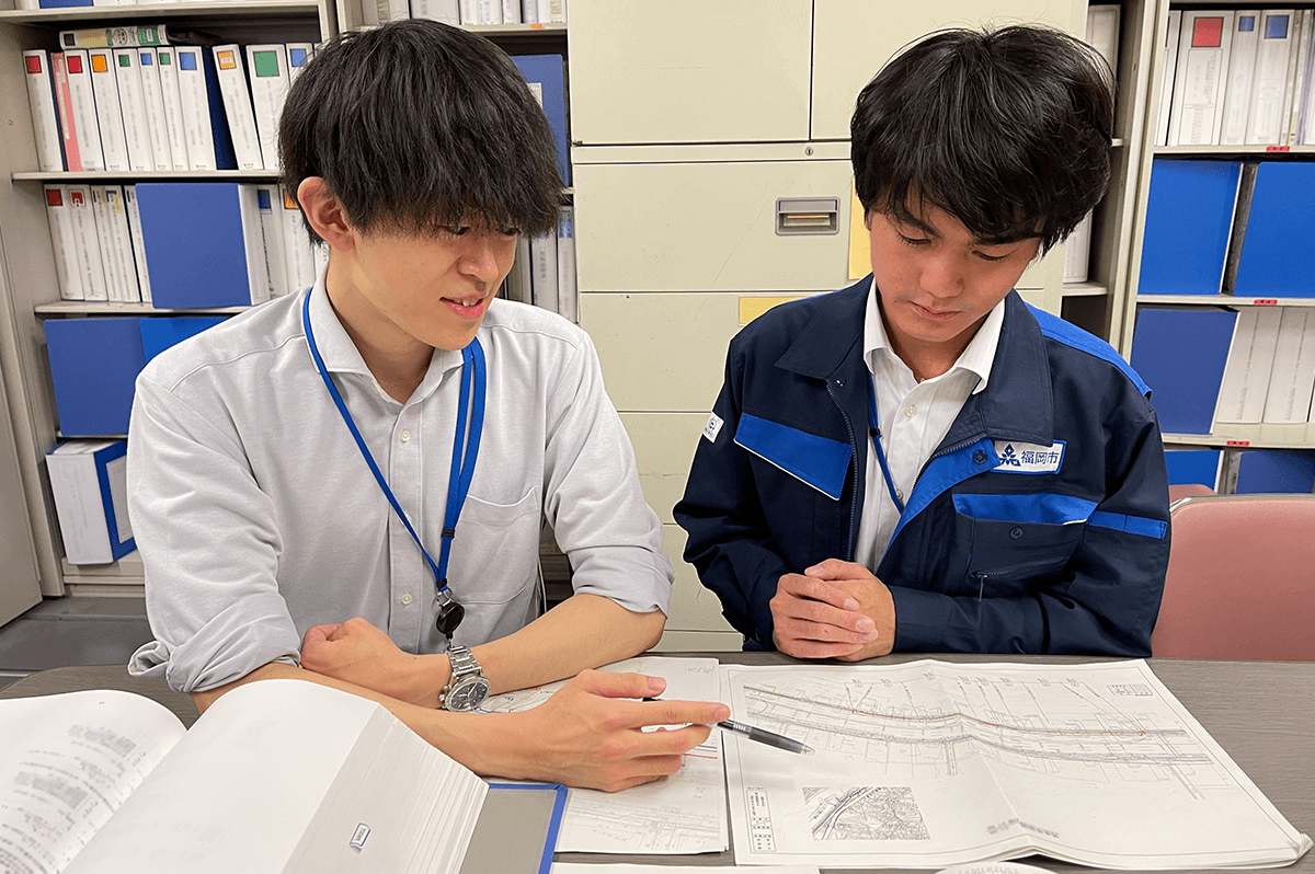 職場で打ち合わせ中の井手さん(福岡市道路下水道局)