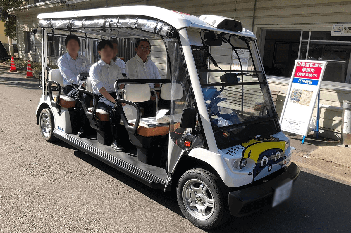 四万十市副市長時代、自動運転車両に登場する森山さん。実験車両には、四万十市西土佐のゆるキャラ「しまっち」がペイントされている(本人提供)