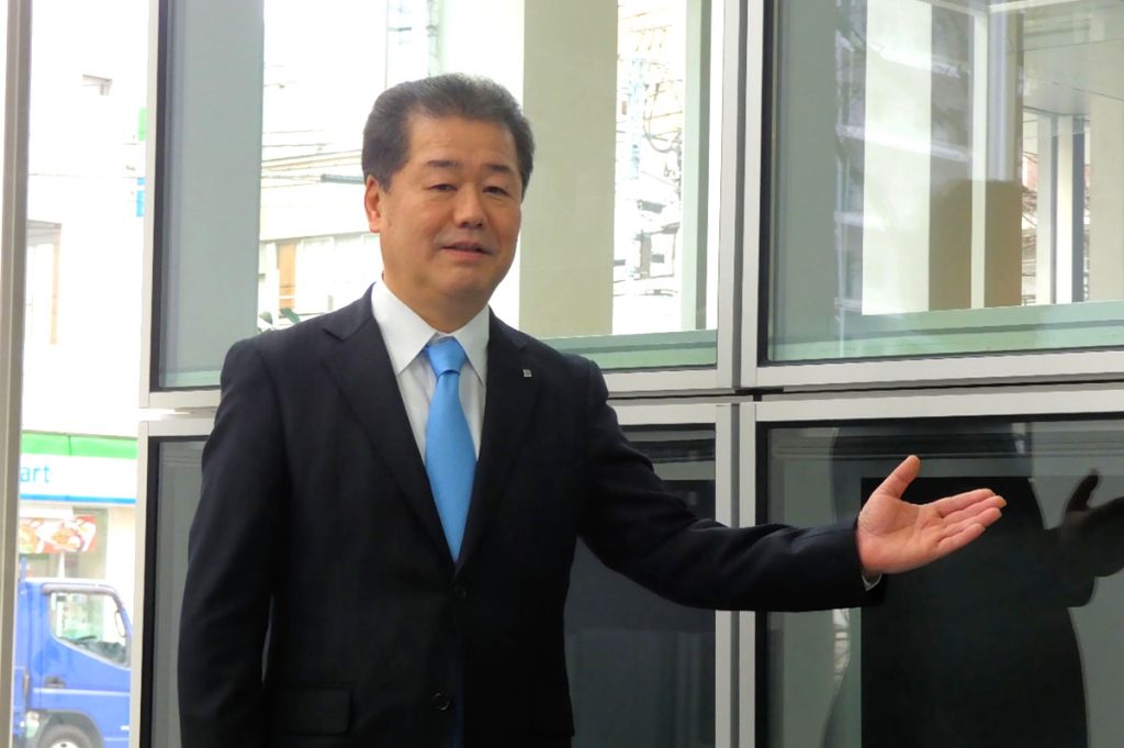 中層建築物向けユニタイズドカーテンウォール「SYSTEMA 81u」を紹介する、YKK APの魚津彰社長