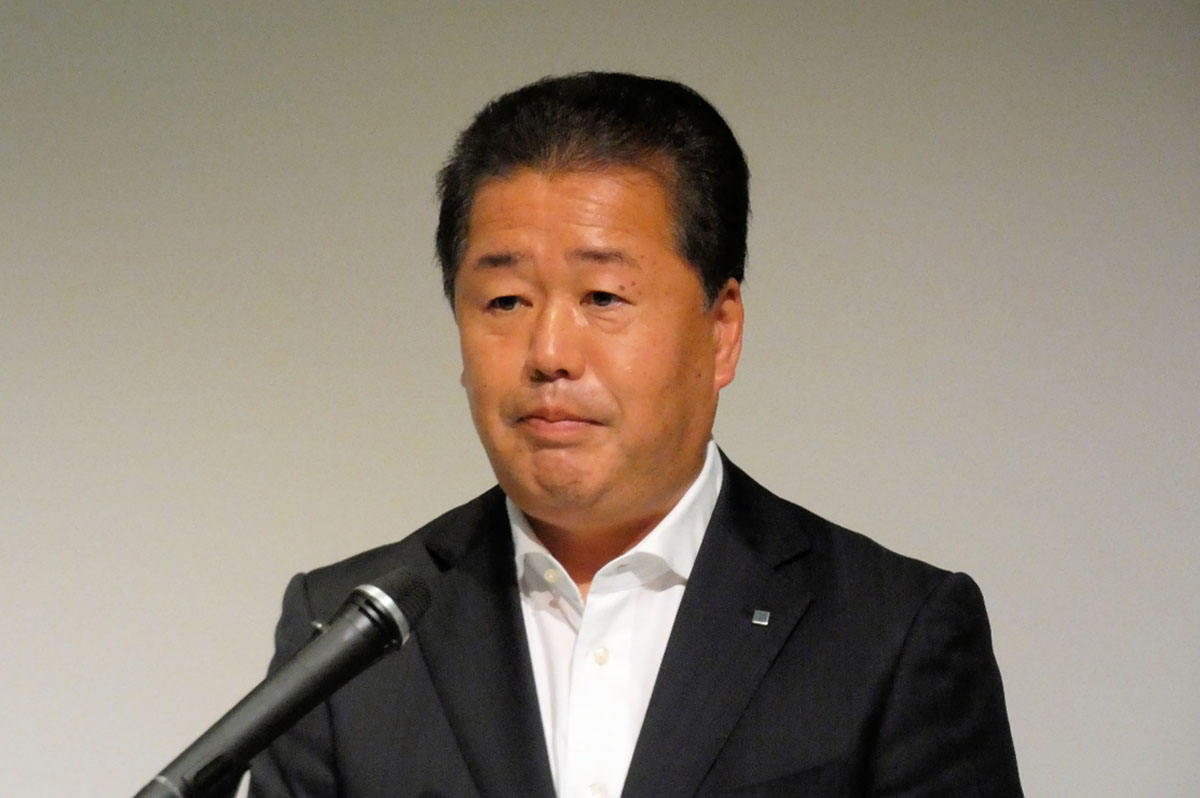 記者会見する魚津社長