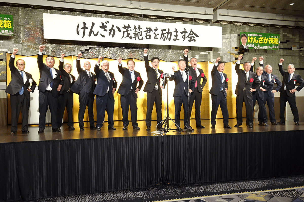 盟友藤井先生（中央右）とともに、ときの声を上げる見坂さん（中央左、けんざか茂範後援会提供）