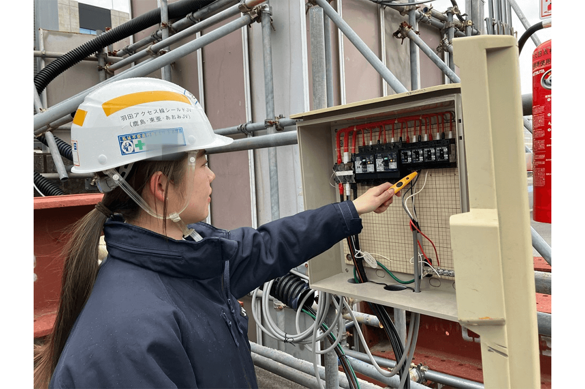 分電盤を点検する鬼頭さん(鹿島JV写真提供)