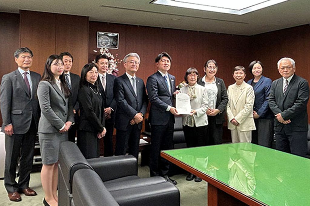 検討会の須田久美子座長が建設産業における女性活躍・定着促進に向けた実行計画を中野洋昌国交相に手交